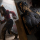 Dead by Daylight killer wearing a pig mask stalks a survivor character dressed in a police uniform.